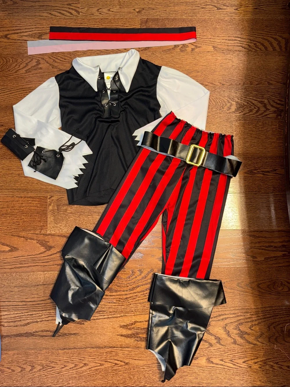 Size s/6-8 pirate costume. Shirt, Pants, Belt, Boot Covers, Scarf, wrist cuffs.